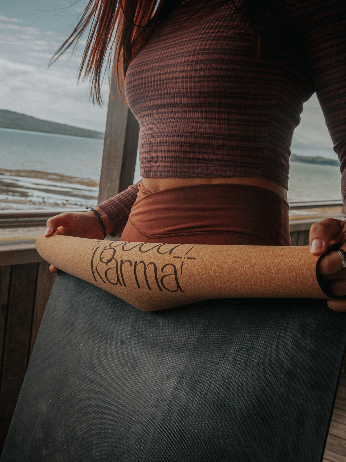 Girl rolling up Good Karma cork yoga mat with body alinement 