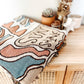 Colorful pattern gypsy style hippie style Woven Boho Quilt Colorful Bohemian Tapestries with tassels folded on rattan cabinet 