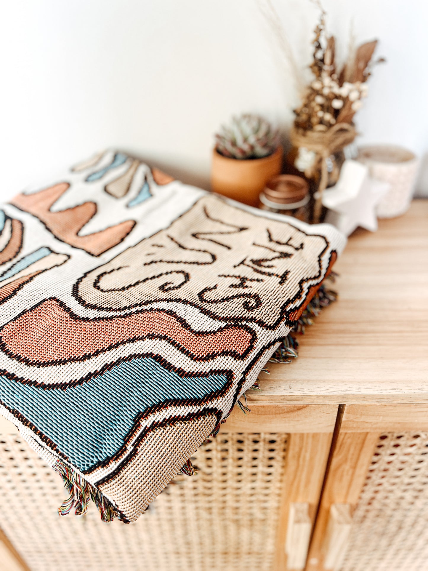 Colorful pattern gypsy style hippie style Woven Boho Quilt Colorful Bohemian Tapestries with tassels folded on rattan cabinet
