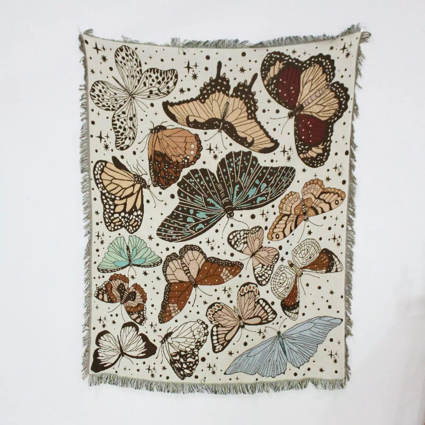 Woven Bohemian Quilt with Colorful Butterflies pattern Large boho tapestry with tassels hanging on white wall