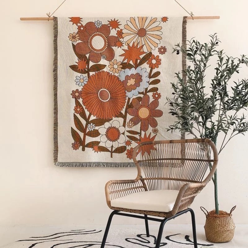 orange and brown Floral pattern Woven Boho Quilt nz Colorful Bohemian Tapestries nz with tassels on white background hanging on the wall like a boho blanket decorative tapestries nz behind rattan chair