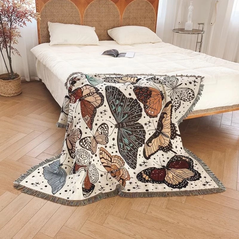Woven Bohemian Quilt with Colorful Butterflies pattern Large boho tapestry with tassels, on the corner of the bed with white bedsheets