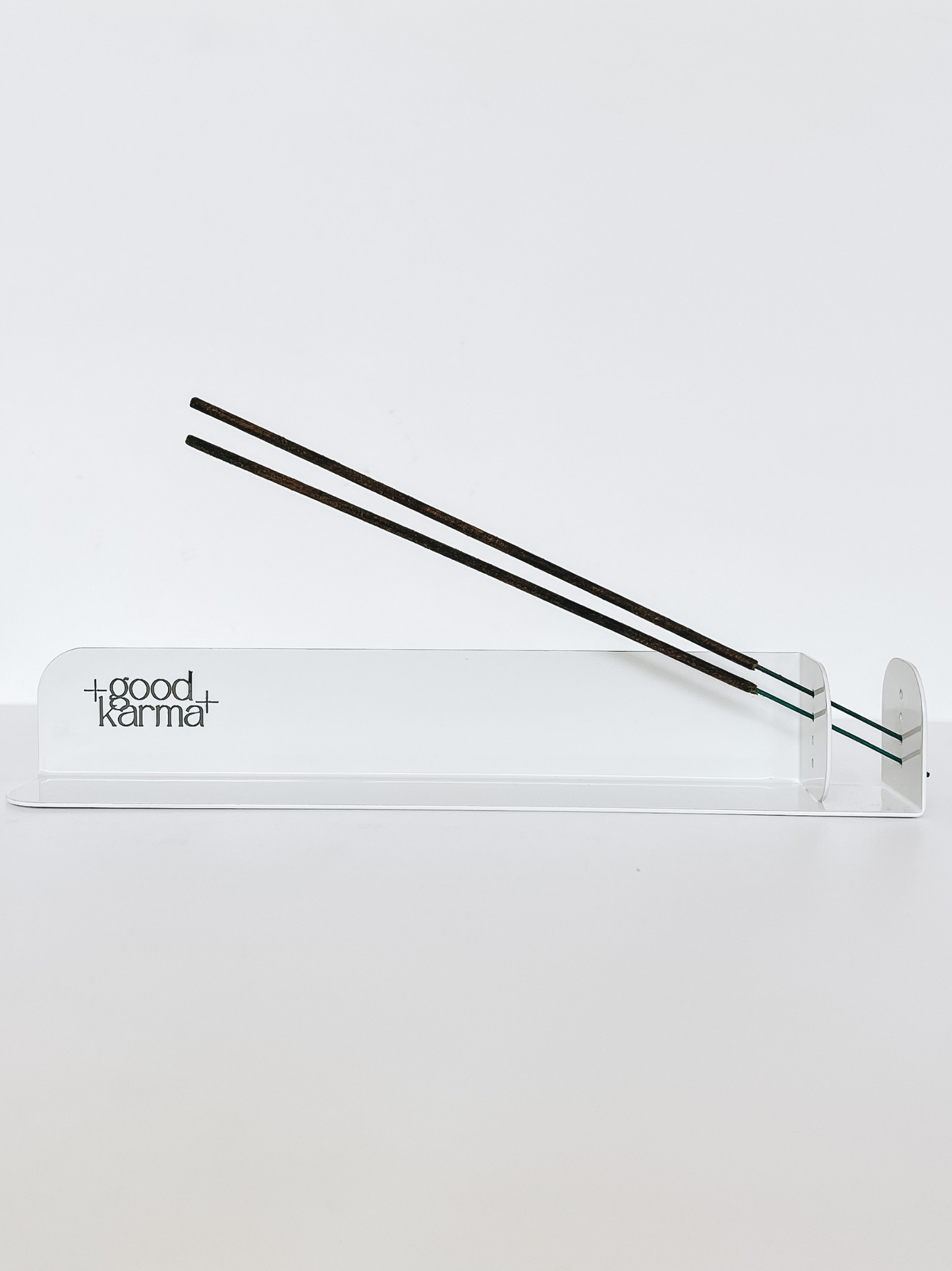 white metal incense sticks holder incense burner with two incense sticks burning at the same tine