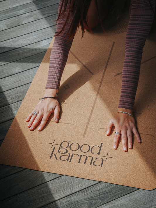 Good Karma cork yoga mat with body alinement on wooden terrace