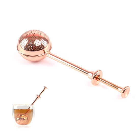 Good Karma tea infuser ball is 2-in-1 scoop and a strainer rose gold color with transparent cup of tea