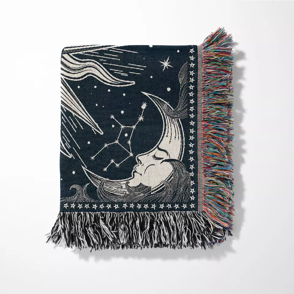 sun and moon and star sky pattern boho woven beach mat with tassels folded on the white background