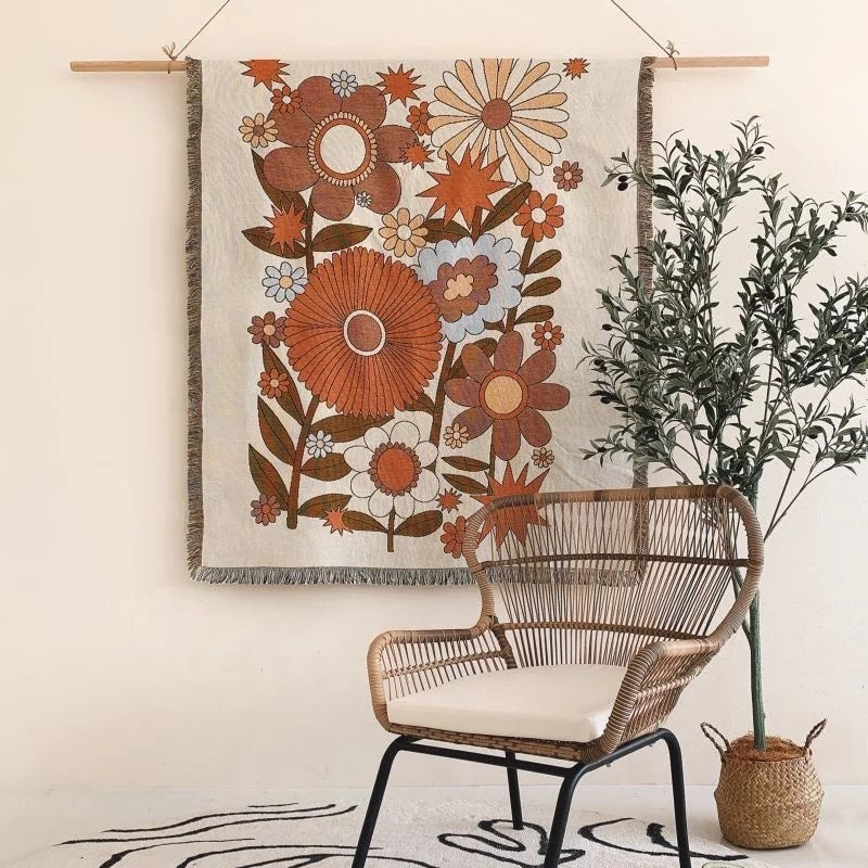 orange and brown Floral pattern Woven Boho Quilt nz Colorful Bohemian Tapestries nz with tassels on white background hanging on the wall like a boho blanket decorative tapestries nz behind rattan chair 